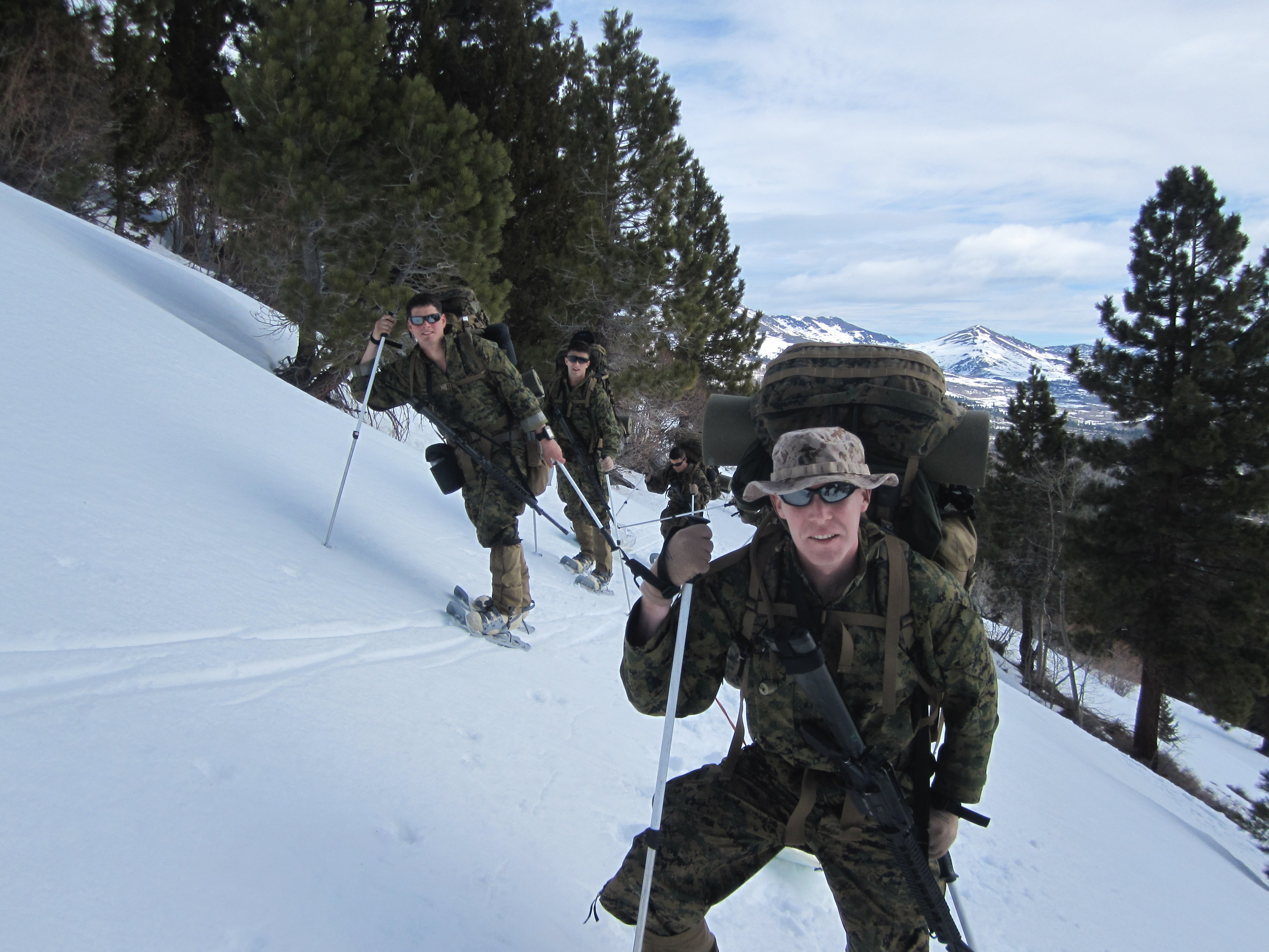 Photo of James Mouton (center right) hiking on a snowy mountain. He is with other marines as part of a military training. 