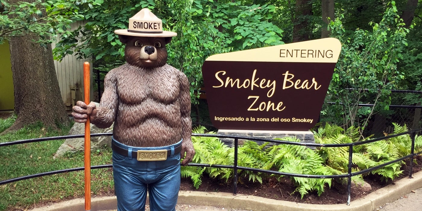 A Smokey Bear statue beside a sign that says "Entering Smokey Bear Zone" at the Smithsonian's National Zoo