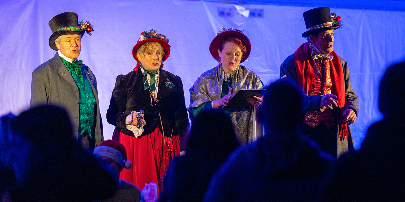 Festive carolers perform on stage at Zoolights.