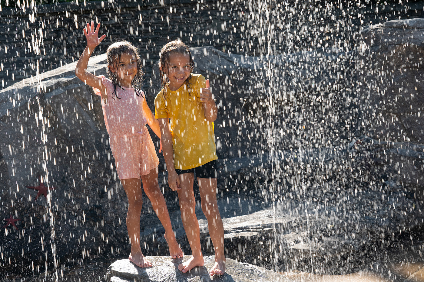 Two children enjoy the aquatic play area near the sea lion exhibit