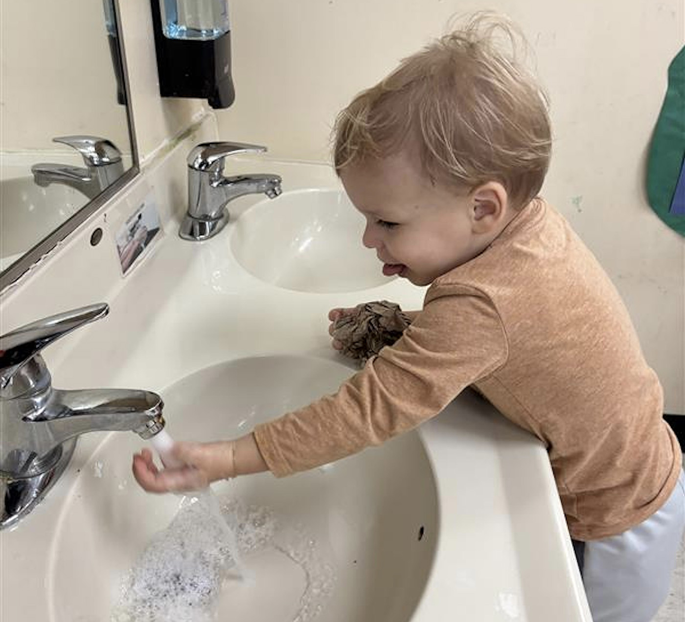 Small child washing hands in a sink