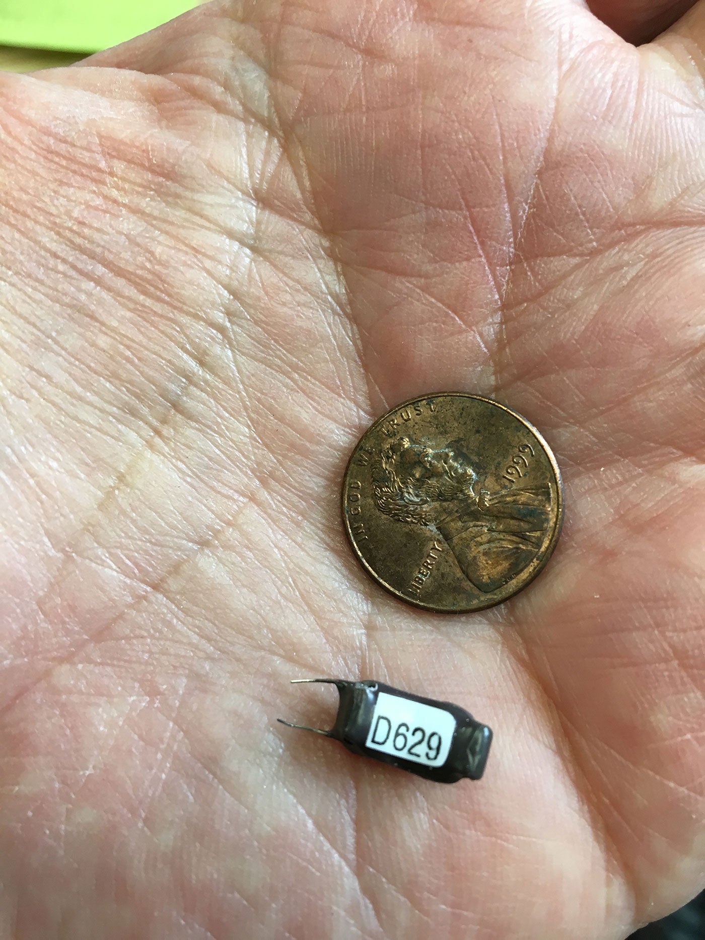 tiny transmitter next to a larger penny