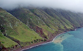 aerial shot of foggy island coastline