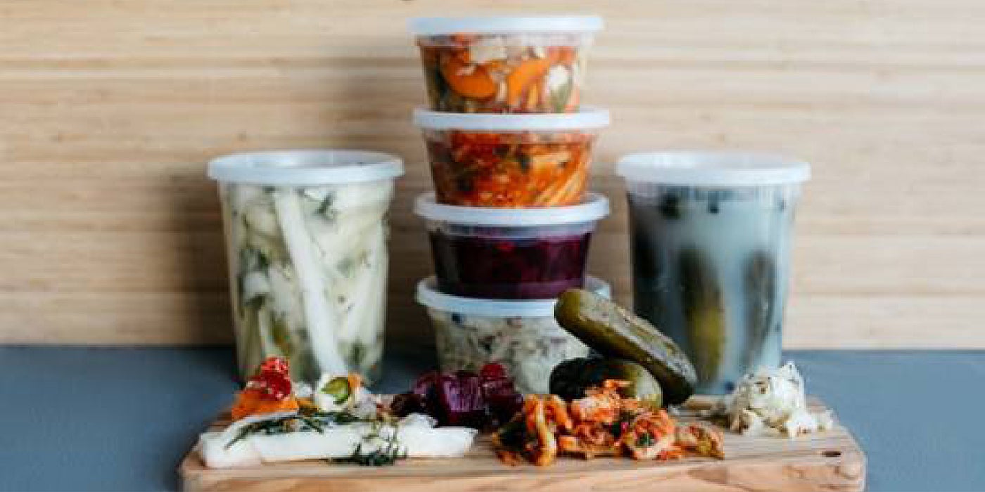 a variety of fermented vegetables in plastic containers