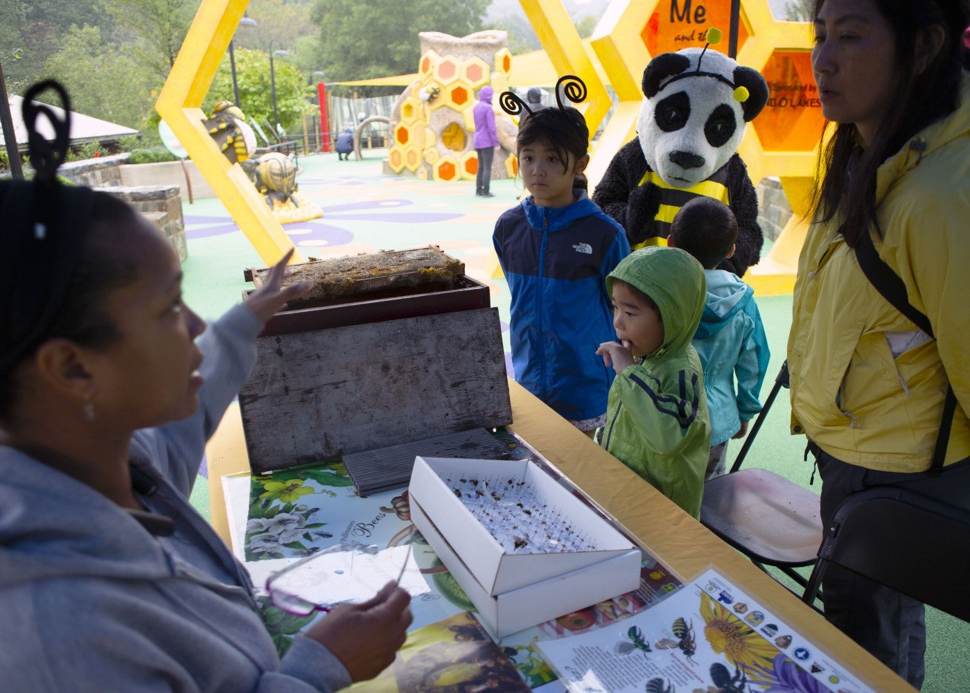 Donna Stockton, an entomologist and animal keeper at Amazonia, speaks with visitors about the importance of pollinators at the Me and the Bee Playground.