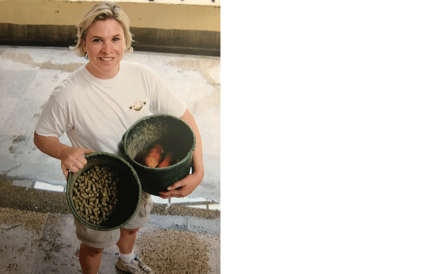 A Zoo volunteer holds two buckets of food for animals