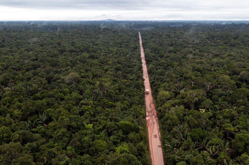 Aerial photo showing a highway cutting through the Amazon rainforest.