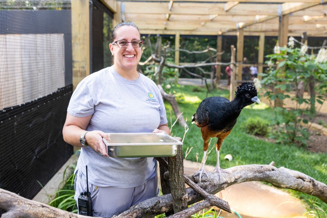 Bird House keeper Heather Anderson and a blue-billed curassow. 