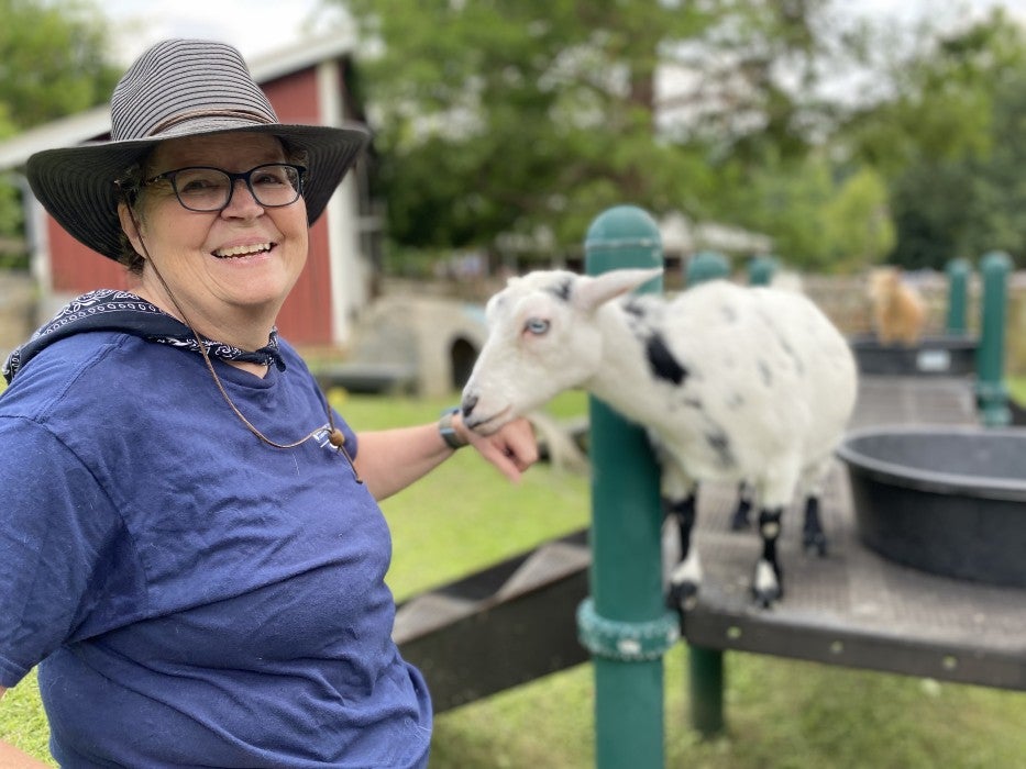 Kids' Farm keeper Kate Volz pets a black-and-white Nigerian dwarf goat named Fiesta.