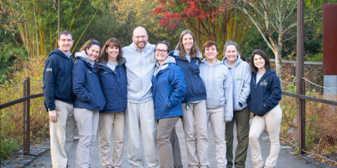 Nine members of the panda keeper team, who are smiling and dressed for cold weather, at the Smithsonian's National Zoo.