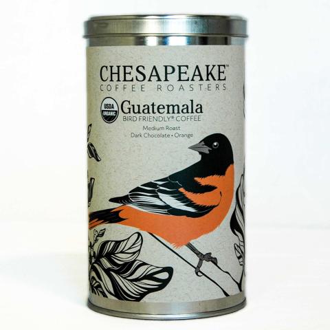 a coffee tin with an image of a Baltimore Oriole perched on a branch and surrounded by leaves