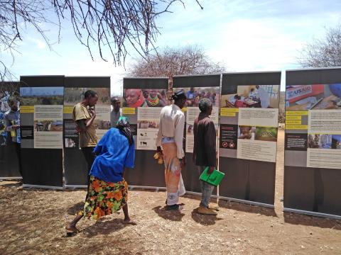Community members in Laikipia, Kenya, examine exhibit panels from the mobile Outbreak DIY exhibit
