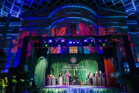 A band plays on a colorfully lit stage at the Smithsonian's National Zoo's Monkey Business Gala
