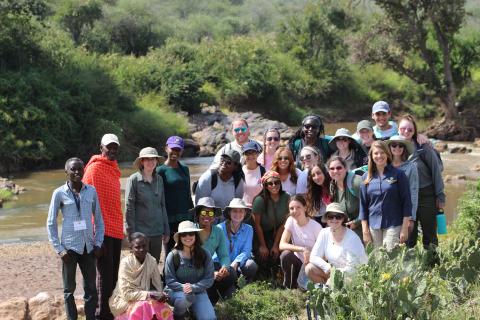 A group of George Mason University undergrad students pose for a photo in the field in Kenya