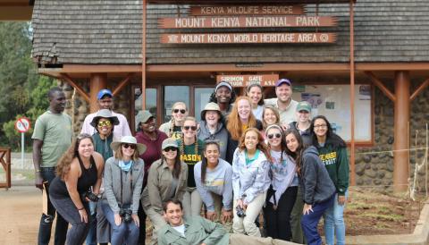 A group of George Mason University students pose in front of a Mount Kenya National Park World Heritage Area building
