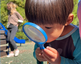 Child holds magnifying glass