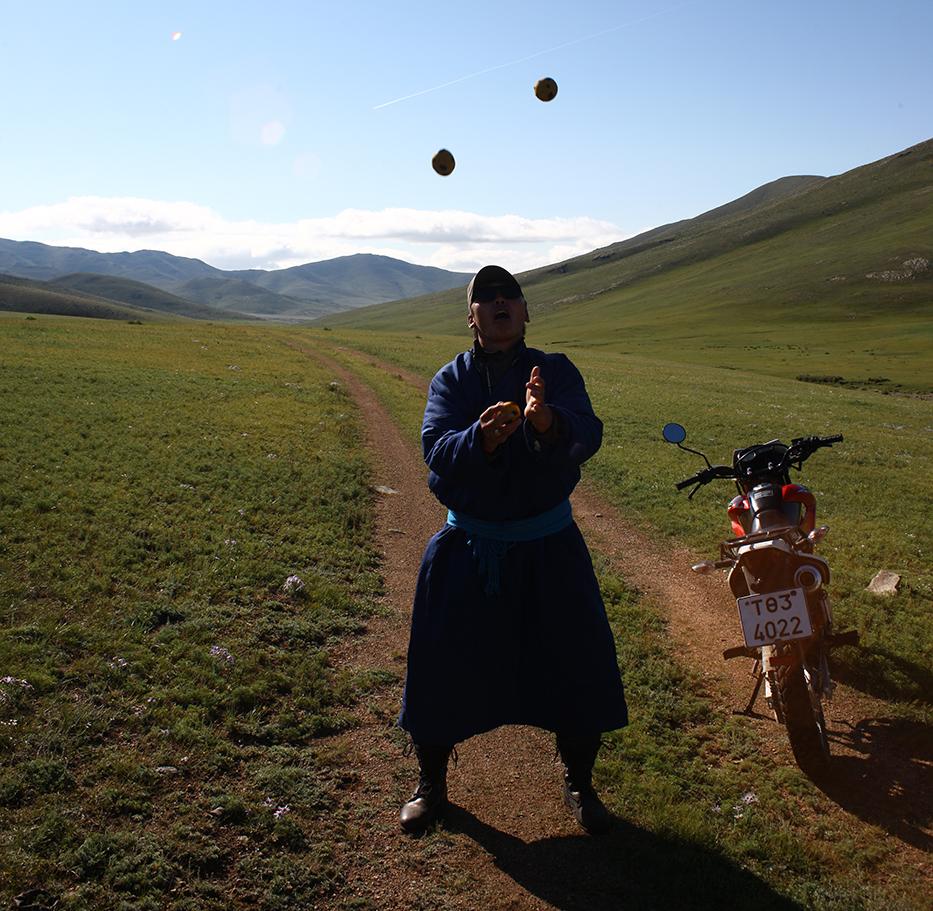 A park ranger in Hustai National Park, Mongolia, juggling next to a motorbike