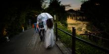 A woman holding an umbrella decorated to look like a jellyfish walks down a path at the Smithsonian's National Zoo during the Boo at the Zoo event