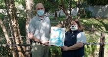 Giant panda keepers Marty Dearie and Nicole MacCorkle hold a painting created by giant panda Tian Tian to reveal that the sex of the giant panda cub is male.