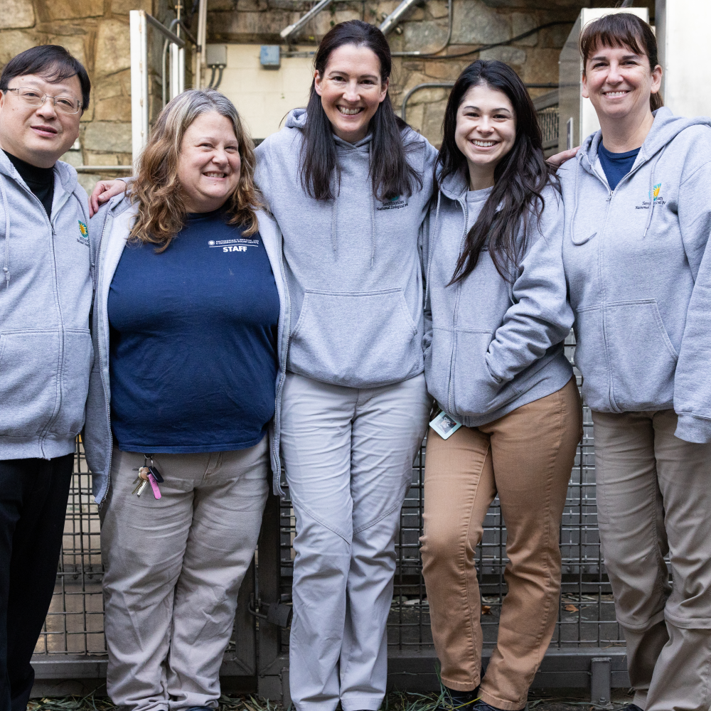 Five panda staffers smile and pose at the Smithsonian's National Zoo.