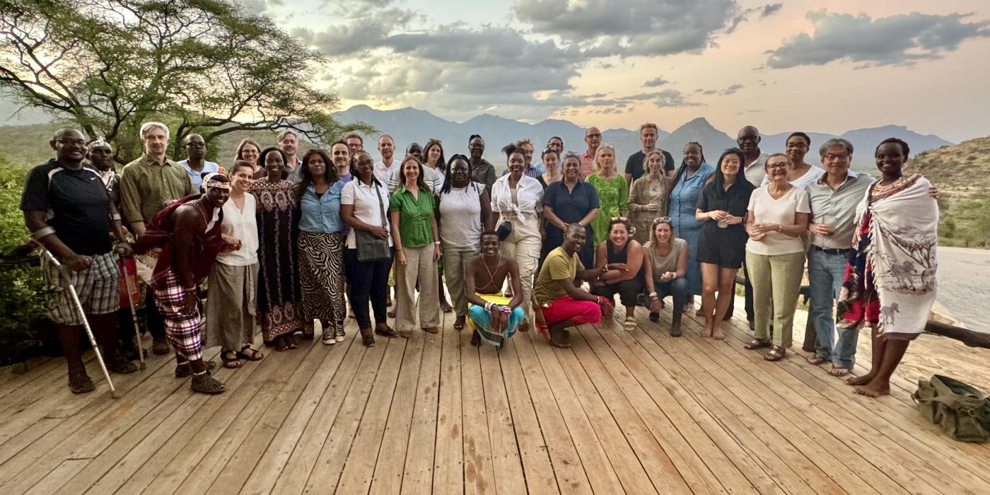 Photo of a large, diverse group of people standing outdoors.