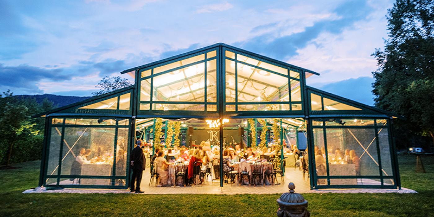 The exterior of the pavilion tent, illuminated against a darkening sky.