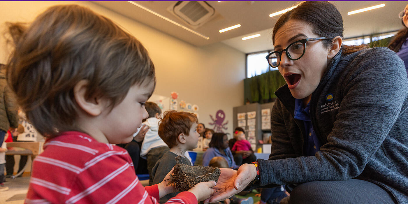 A Zoo educator interacts with a toddler.