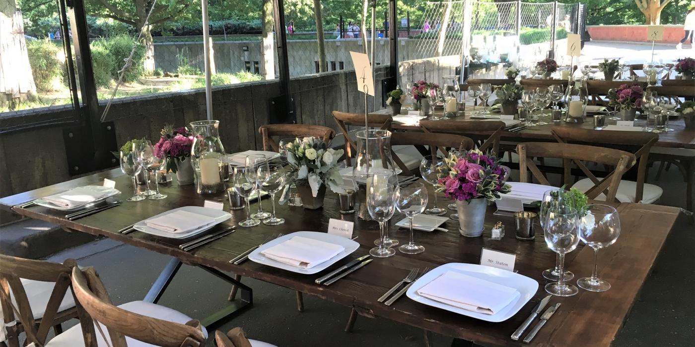 A table set for a meal with flower centerpieces at the Smithsonian's National Zoo's Great Cats exhibit