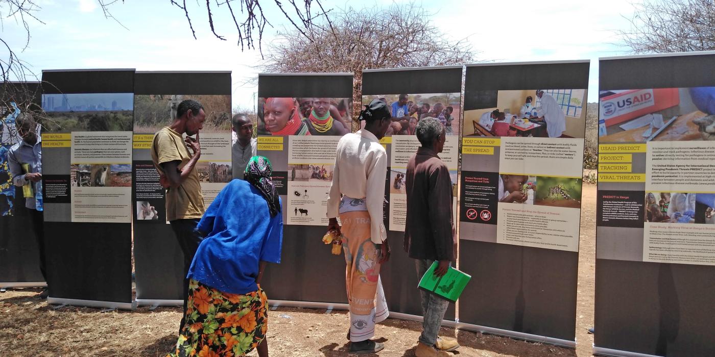 Community members in Laikipia, Kenya, examine exhibit panels from the mobile Outbreak DIY exhibit