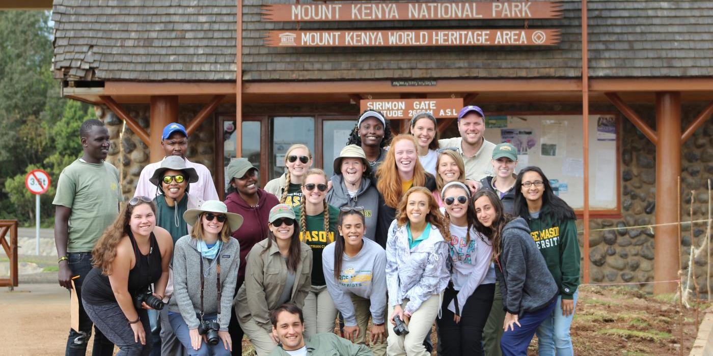 A group of George Mason University students pose in front of a Mount Kenya National Park World Heritage Area building